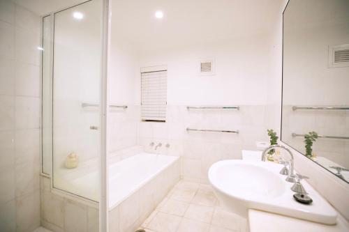悉尼Central New York Style Warehouse的白色的浴室设有浴缸和水槽。
