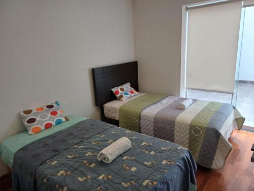 利马Habitación acogedora Aramburú的小型客房 - 带2张床和窗户