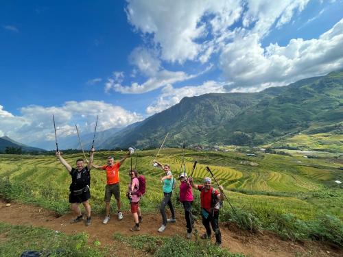 萨帕SaPa Big Tree Hmong Homestay的一群人站在山上,手放在空中