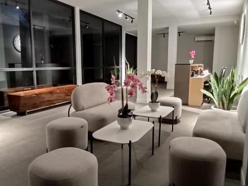 TanjungubanONYX HOTEL & VILLA的客厅配有沙发、椅子和鲜花。