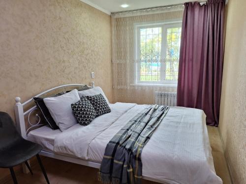乌斯季卡缅诺戈尔斯克Аппартаменты 2 / х комнатная的卧室配有带枕头的床铺和窗户。