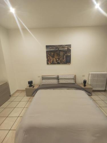 诺瓦拉Appartamento c&y Monte san Gabriele的卧室配有一张大床,墙上挂有绘画作品