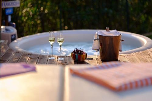 伊斯普拉La Luna nel Lago Lake View Garden - Happy Rentals的一张桌子,配有两杯葡萄酒和一个浴缸