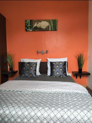 穆斯泰Le Domaine的一间卧室配有一张橙色墙壁的床