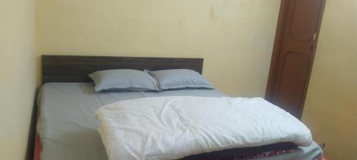 ShamshiKullvi hill homestay的一张带白色床单和枕头的床