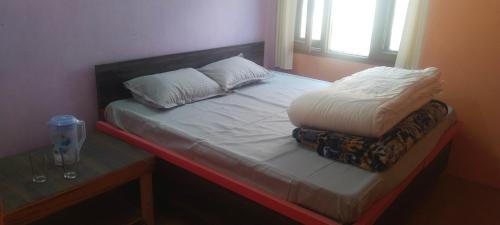ShamshiKullvi hill homestay的一张带两张枕头的床和一张桌子