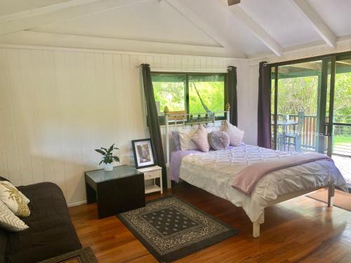 宁宾Nimbin waterfall retreat的一间卧室配有一张床和一张沙发