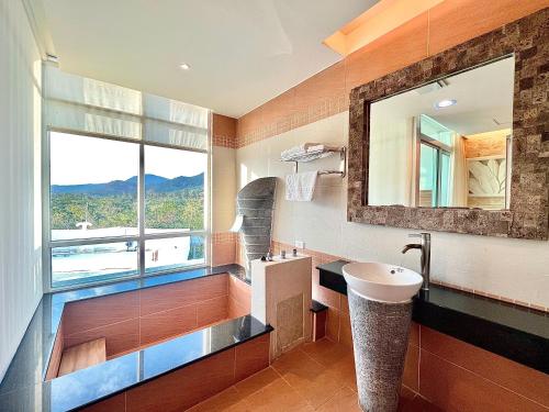 垦丁大街四季峇里时尙旅店的一间带水槽和镜子的浴室以及窗户。