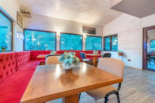 泽尔内什蒂Resort 7 Crai - Cabana Craiul Crailor的一间设有桌子和红色沙发的房间