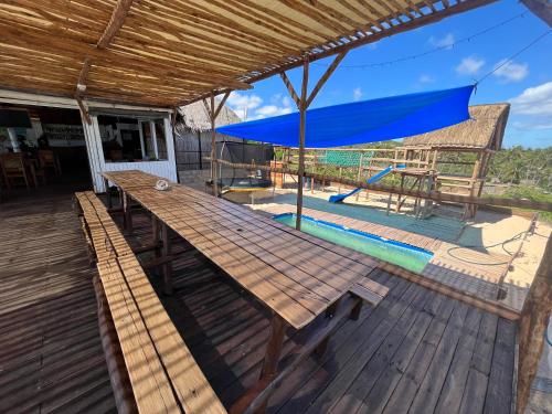 托弗海滩Mango Beach Resort的甲板上配有带蓝色遮阳伞的木桌