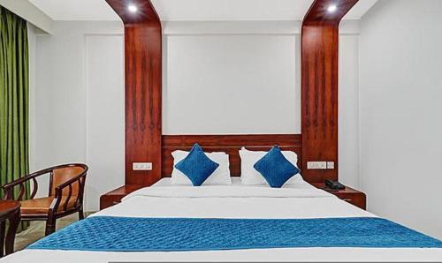 特里凡得琅FabHotel Majestic South Gate的一间卧室配有一张带蓝色枕头的大床