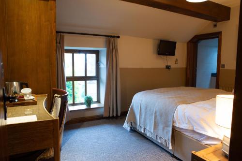 LongnorYe Olde Cheshire Cheese的一间卧室配有一张床、一张书桌和一个窗户。