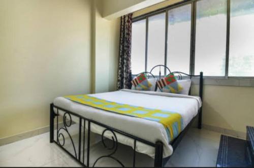 纳威孟买Cozy Stay Kharghar的卧室内带窗户的房间里的一个床位