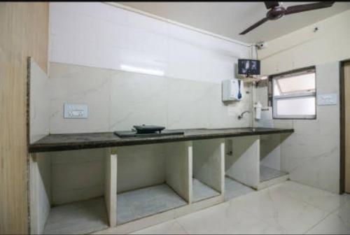 纳威孟买Cozy Stay Kharghar的一间厨房,在房间内有长柜台