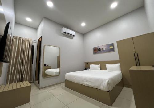 金沙萨Ixoras Hotel Victoire的一间卧室配有一张大床和镜子