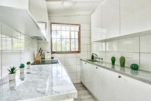悉尼Comfortable 2 Bedroom House Paddington 2 E-Bikes Included的白色的厨房设有大型大理石台面