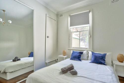 悉尼2 Bedroom House Darling Harbour Kent St的一间卧室配有镜子和一张带蓝色枕头的床