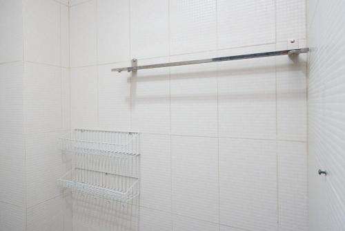 日惹RedDoorz near Affandi Gejayan 2的白色瓷砖淋浴间,配有毛巾架