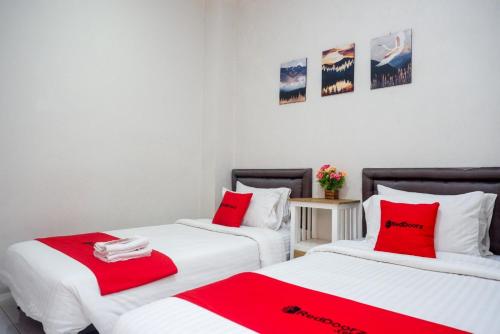 日惹RedDoorz near Affandi Gejayan 2的配有红色和白色床单的客房内的两张床