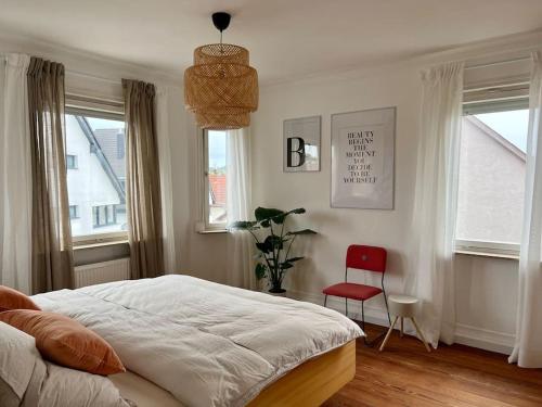 罗伊特林根Gemütliche Altbauwohnung in RT-Betzingen的一间卧室配有一张床和一张红色椅子