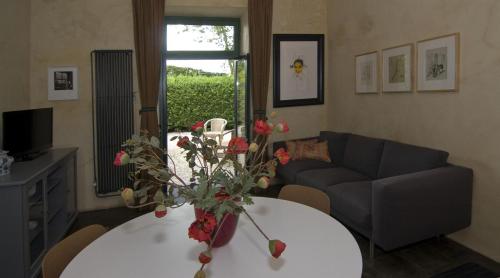 贝梅伦b&b Het Wolfshuis的客厅配有沙发和鲜花桌
