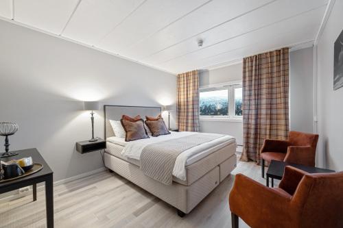 Nord TorpaSpåtind Fjellhotell的一间卧室配有一张床、一张桌子和一把椅子
