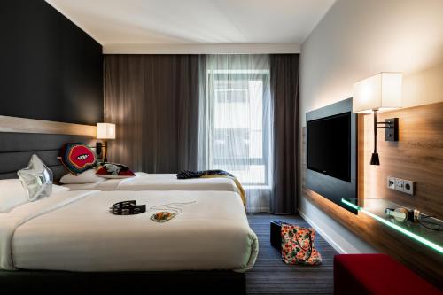 豪士罗伦敦希思罗机场慕奇夕酒店的酒店客房设有两张床和一台平面电视。