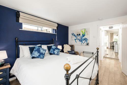 LlanfaesFisherman Cottage Llanfaes near Beaumaris的一间卧室拥有蓝色的墙壁,配有一张带蓝色枕头的床。