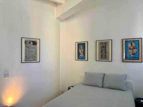 洛桑Loft industriel en duplex - The Urban Garage的卧室配有一张四幅画的墙壁床。