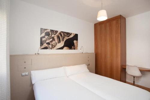 巴塞罗那Ola Living Sagrada Familia的卧室配有白色的床和木制橱柜。