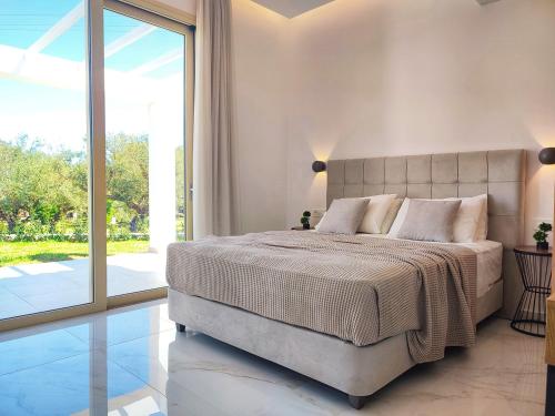 普莱诺斯Villa Mavra的一间卧室设有一张大床和一个大窗户