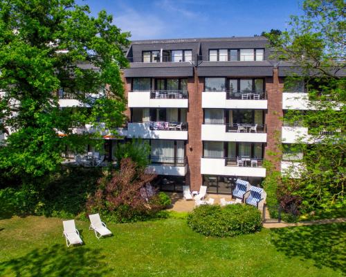 蒂门多弗施特兰德Appartement-Hotel Timmendorfer Strand的公寓大楼设有草坪椅庭院。