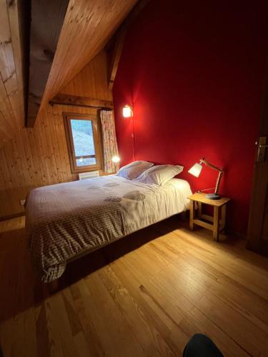 圣皮耶尔德沙尔特勒斯Le Chal'heureux , grand chalet familial 8 personnes的一间卧室配有一张红色墙壁的床