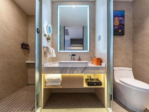 重庆维也纳国际重庆江北嘴金融中心酒店的一间带水槽、卫生间和镜子的浴室
