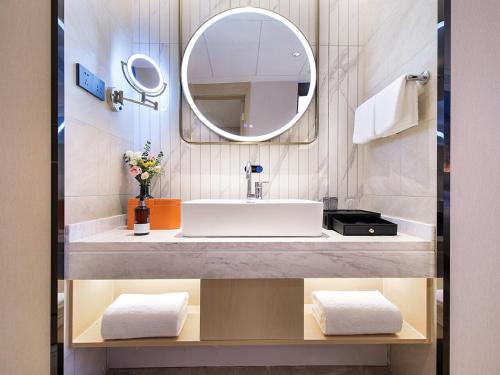 兰州维也纳国际兰州安宁砂之船黄河之滨酒店的一间带水槽和镜子的浴室