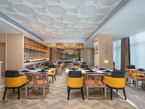 成都维也纳国际成都双流机场航站楼北京华联酒店的一间设有黄色桌椅的餐厅和一间酒吧
