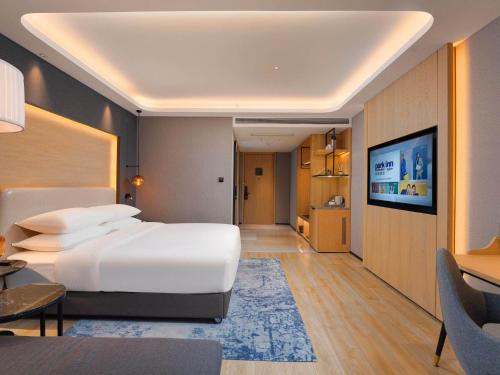 天津丽柏酒店天津空港滨海国际机场店的卧室配有一张白色大床和电视。