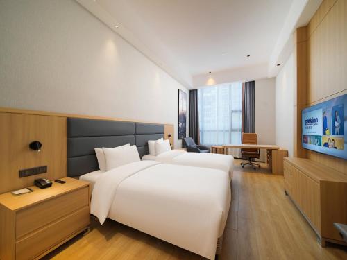 Xingqianjie丽柏酒店温州龙湾国际机场万达广场的酒店客房设有一张白色大床和一台电视。