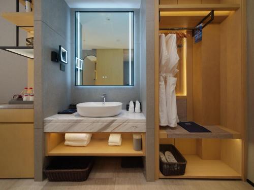 新都丽柏酒店成都凤凰山体育公园的一间带水槽和镜子的浴室