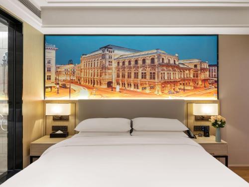 同安区维也纳国际厦门同安工业集中区酒店的大楼前的卧室配有一张白色大床