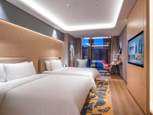 铜陵丽柏酒店安徽铜陵北斗星城店的酒店客房设有两张床和大窗户。