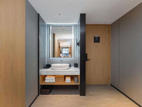 静海区丽柏酒店天津静海万达广场的一间带水槽和镜子的浴室