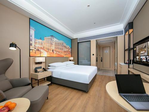成都维也纳国际成都双流机场航站楼北京华联酒店的酒店客房配有一张大床和一台笔记本电脑