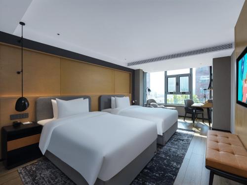 禹城丽柏酒店山东禹城高新区德百广场的配有电视的酒店客房内的两张床
