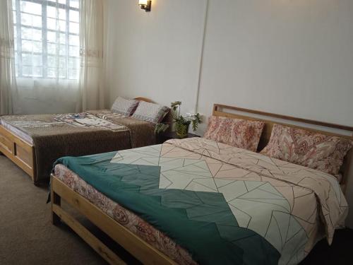 大吉岭Vilasa Homestay的卧室配有床和床,铺有四柱床。