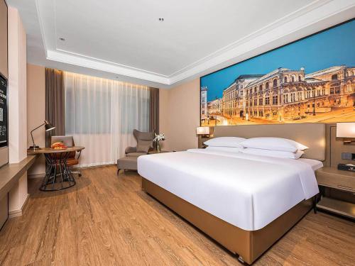 咸阳维也纳国际西安咸阳国际机场酒店的一张大白色床,位于酒店带绘画的房间