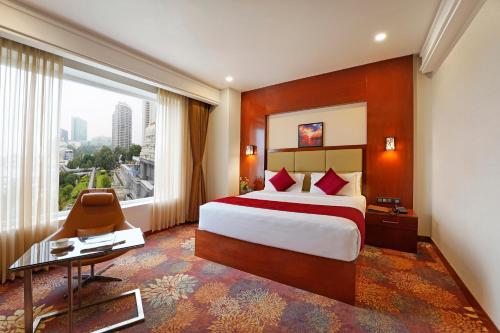 班加罗尔KINGSTON HOTEL的酒店客房设有一张床和一个大窗户