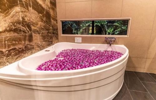 东京BaliAn Resort Forest Ikebukuro的浴室内装有粉红色花卉的浴缸