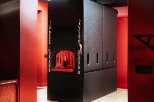 维尔纽斯BDSM Red Apartments的黑色橱柜,里面装着红色椅子