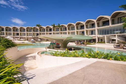富国富国岛贝壳Spa度假酒店 的一座大型建筑,前面设有一个游泳池